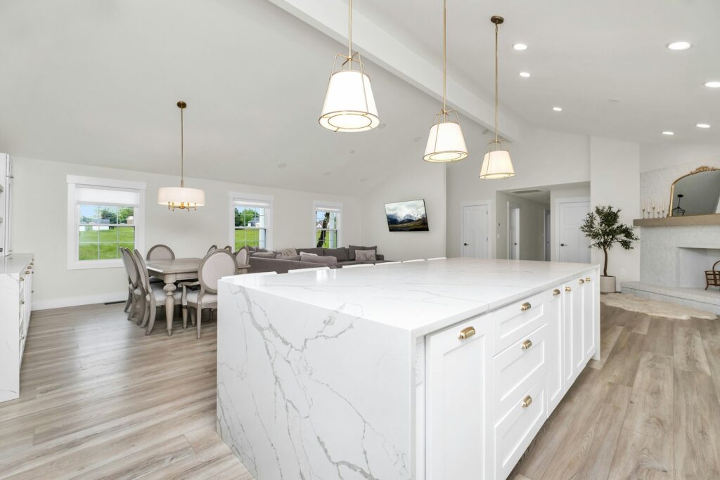 Professional real estate photography of white kitchen with marble island